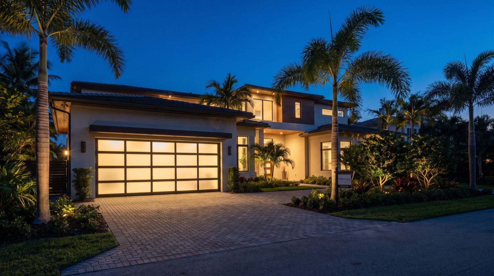 Modern glass garage door on a luxury Florida home at twilight